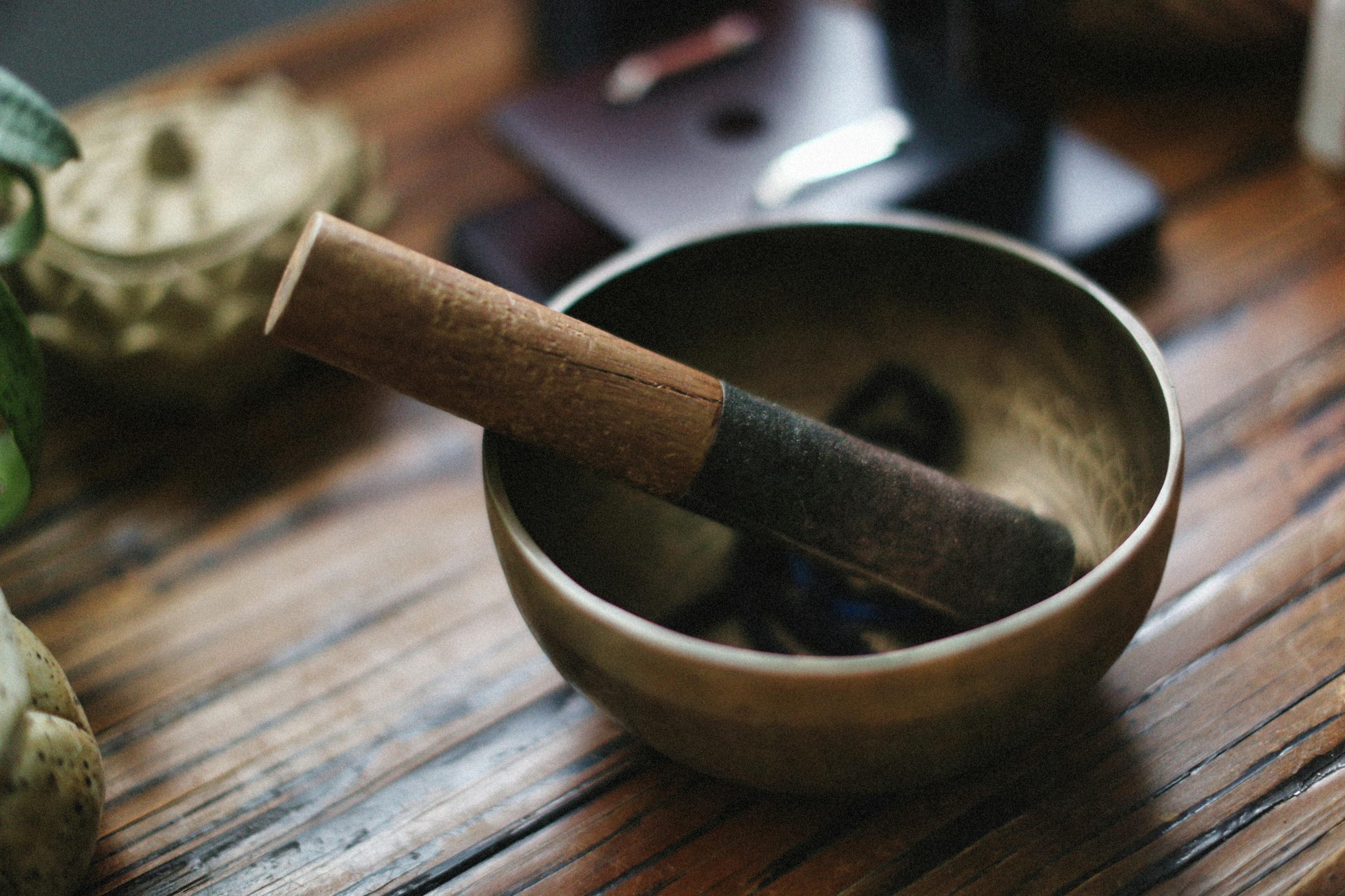 pexels-photo-32633637-32633637 A close-up of a traditional singing bowl with a mallet on a wooden table, creating a serene atmosphere.