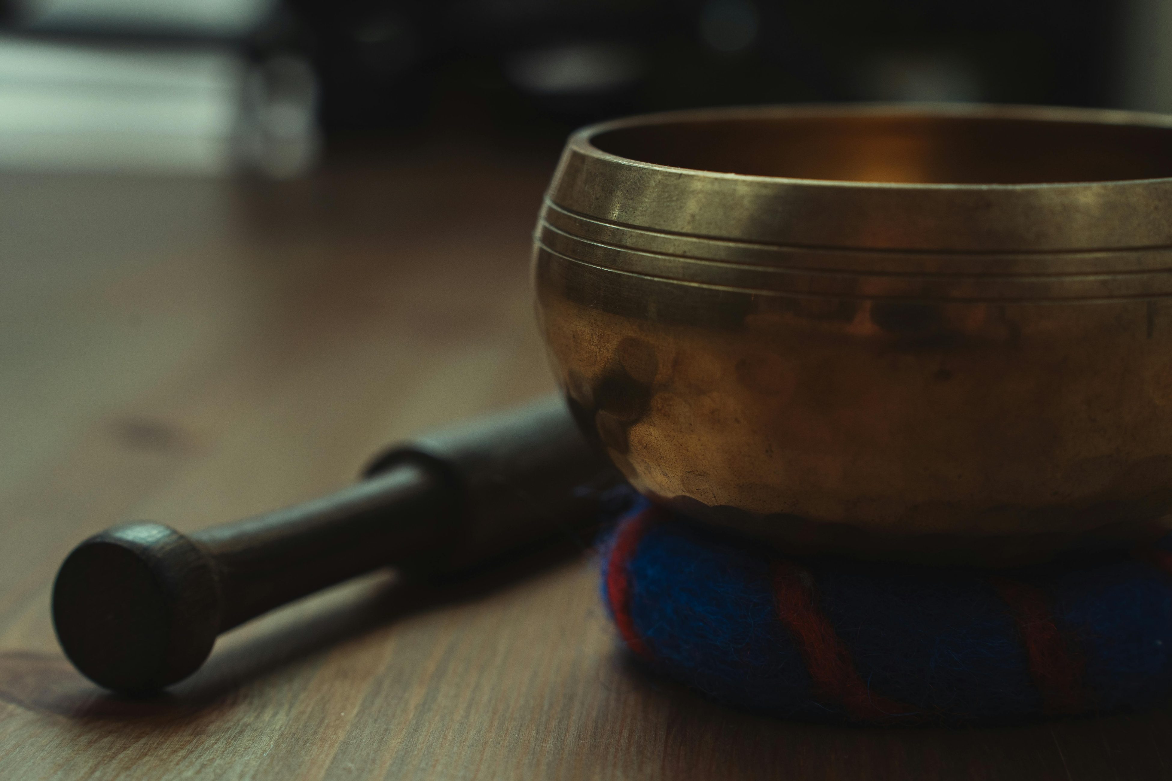 Close-up of a Tibetan singing bowl on a wooden table, ideal for sound therapy and relaxation.