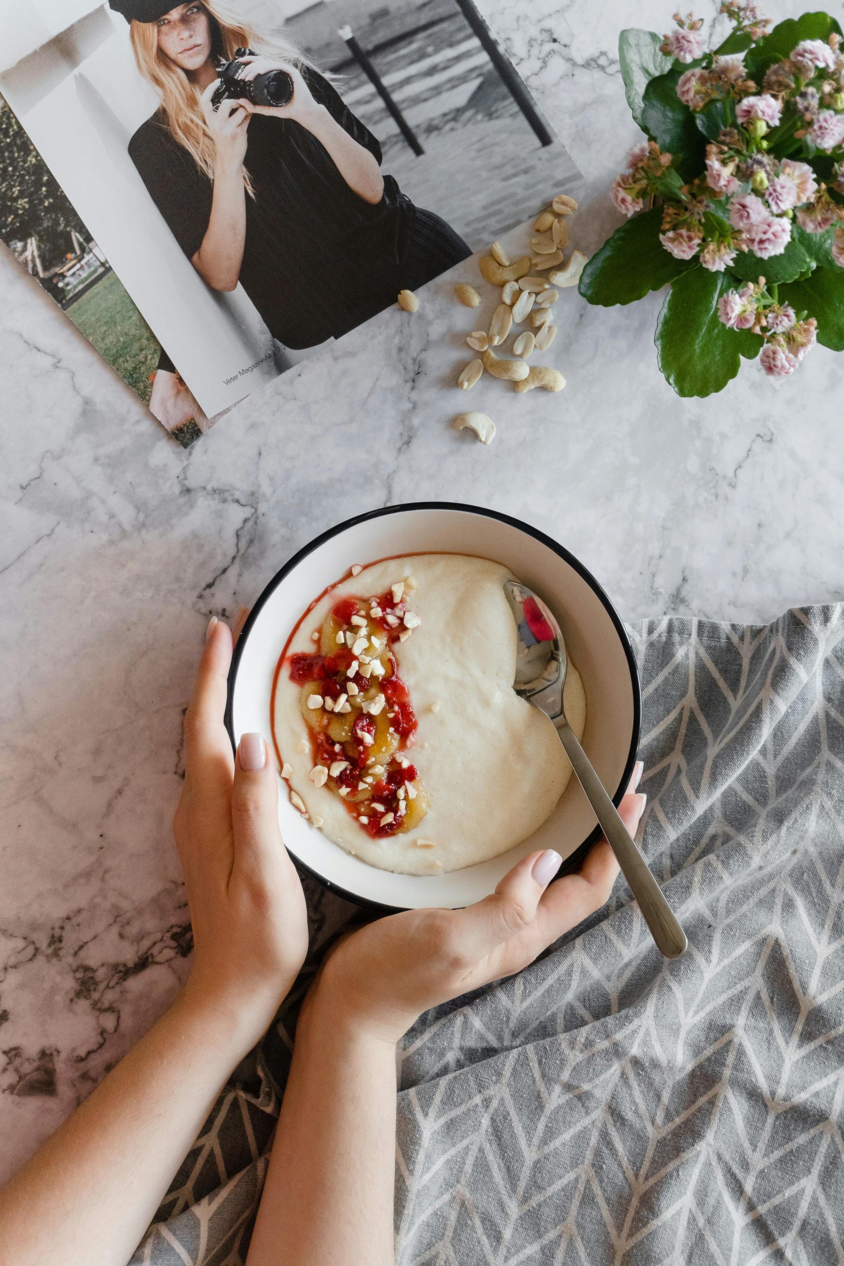 A top-down view of a cozy breakfast with creamy porridge topped with vibrant fruits and nuts.